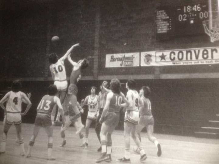 Blacj & white image of Scottish Basketball Final of 1976 - crowd of players with two leaping higher for the ball.